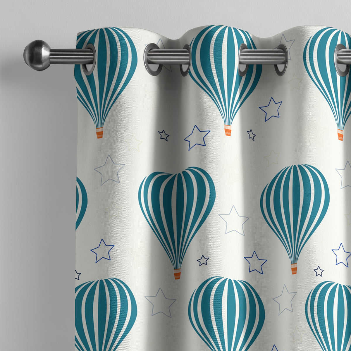 Teal hot air balloon nursery curtain on a grommet rod, close-up of the print