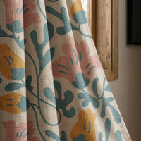 Teal and pink abstract floral curtain panel beside a rustic wooden window
