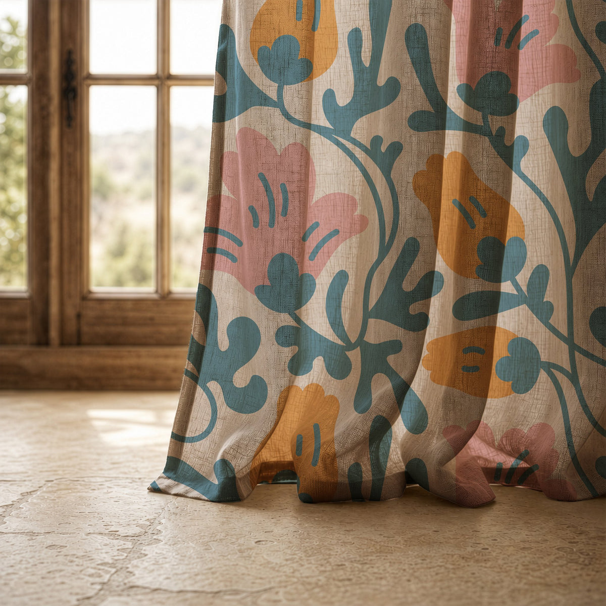 Hem of a teal and pink abstract floral curtain resting on a stone floor