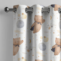 Teddy bear and moon nursery curtain on a grommet rod, close-up of the print