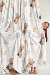 Pair of teddy bear and moon nursery curtains in a child's bedroom