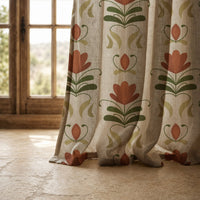 Hem of a terracotta folk tulip curtain resting on a stone floor