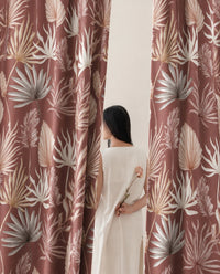 Woman standing between two terracotta palm leaf curtain panels