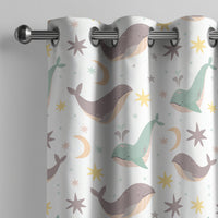 Whale nursery curtain on a grommet rod, close-up of the print