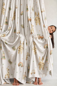 Wooden toy and giraffe nursery curtains styled with neutral decor